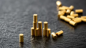Gold cylindrical metal pins on a dark textured surface